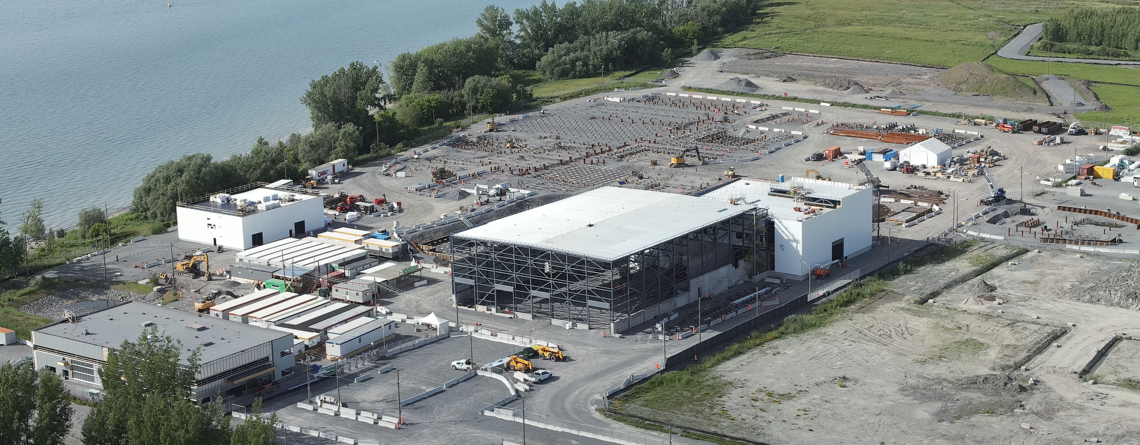 Vue d’ensemble du chantier Varennes Carbon Recycling avec bâtiments industriels, structures d’acier et zones de fondations.
