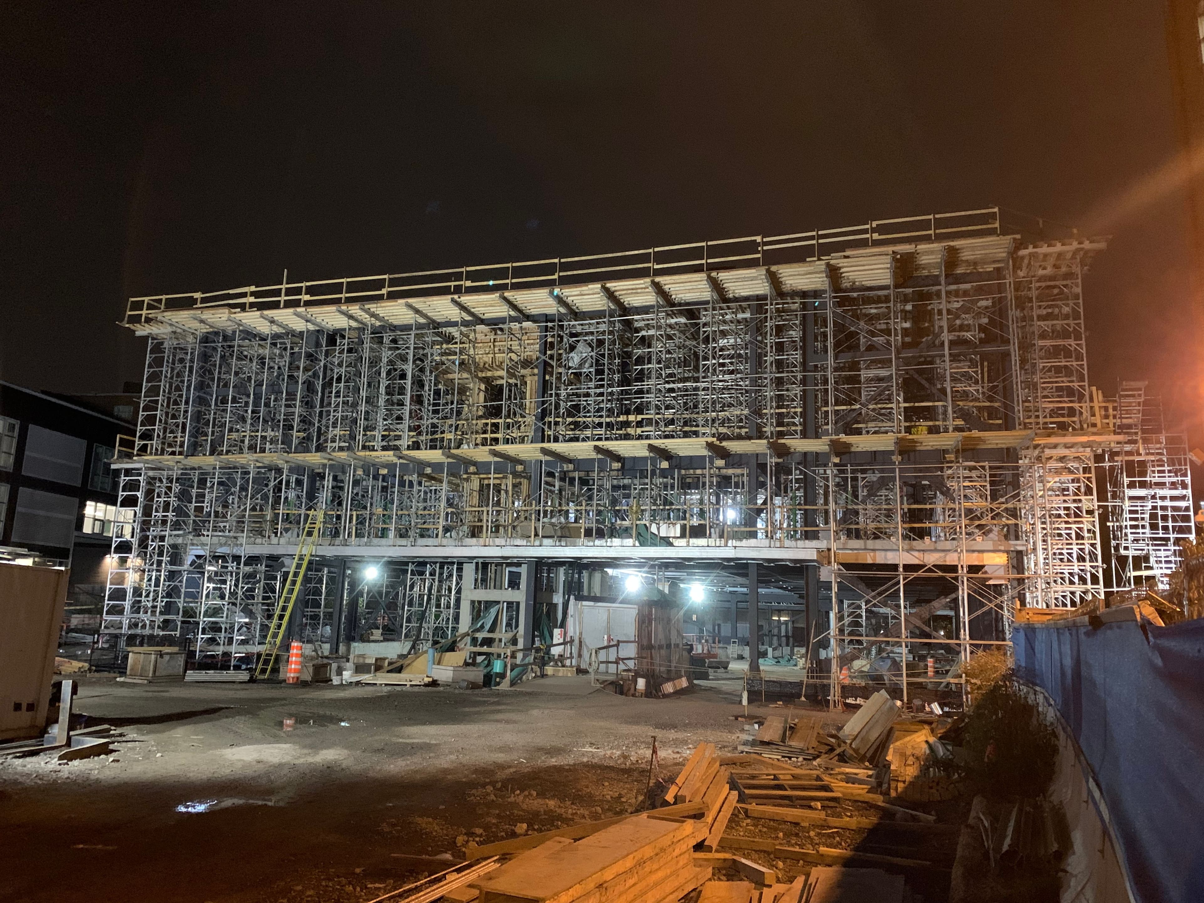Vue nocturne du chantier du poste de district Lionel-Groulx avec échafaudages complets et structure en élévation réalisé par CSL Ltée