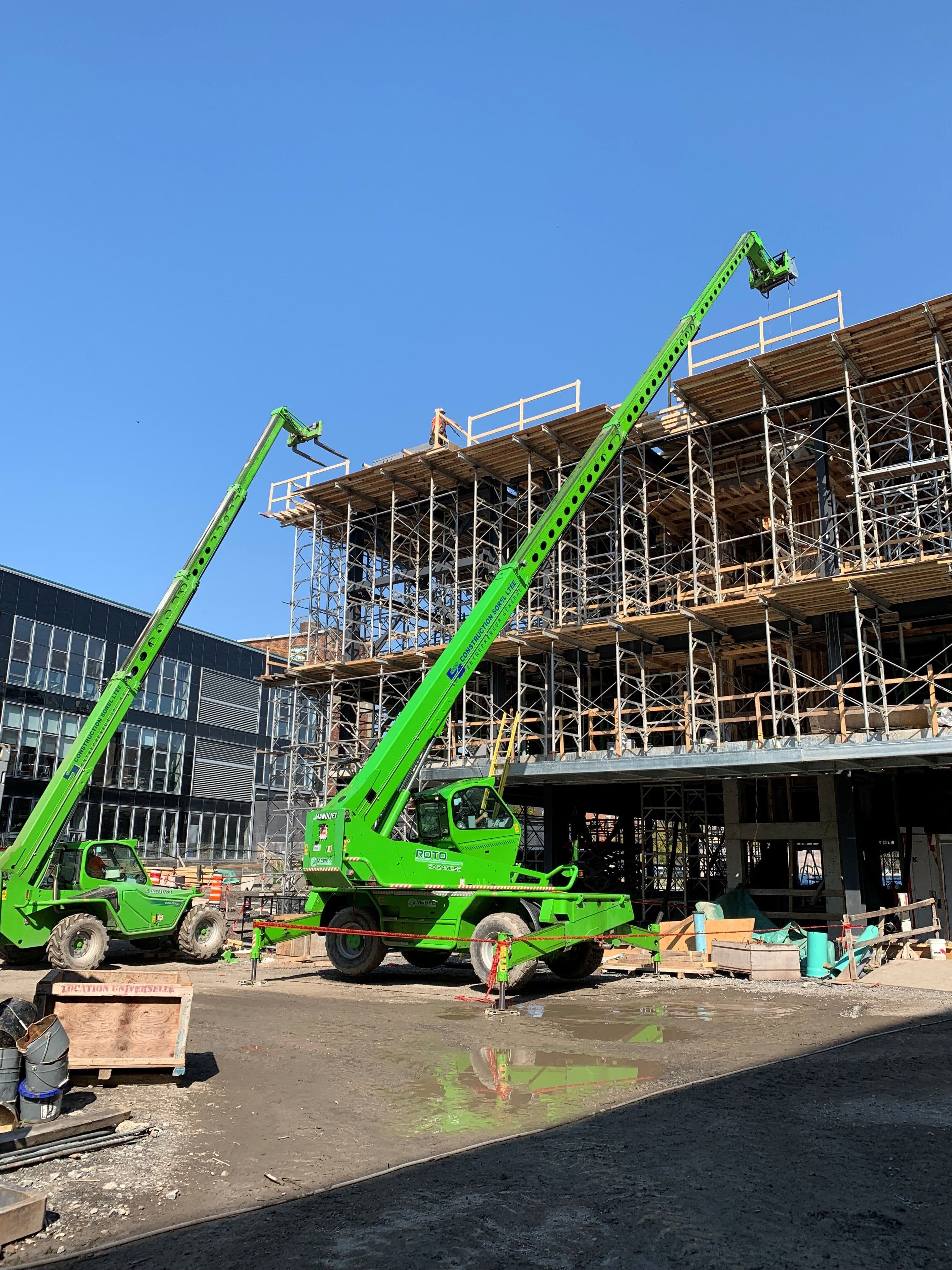 Travaux de coffrage et de structure avec plateformes élévatrices vertes installées autour d’un bâtiment en construction réalisé par CSL Ltée