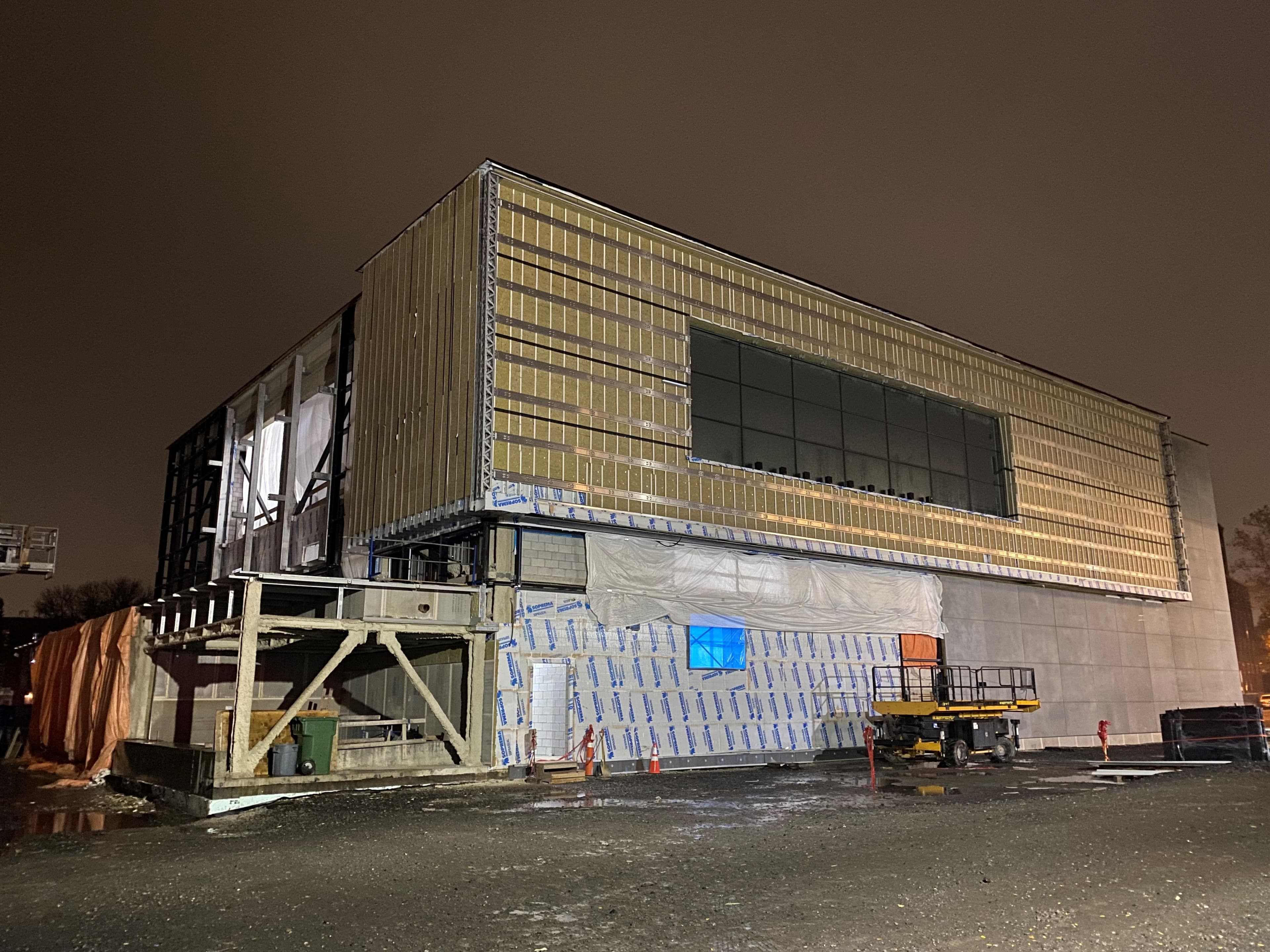 Bâtiment institutionnel en cours de construction de nuit, montrant la structure apparente et l’enveloppe partiellement installée réalisé par CSL Ltée