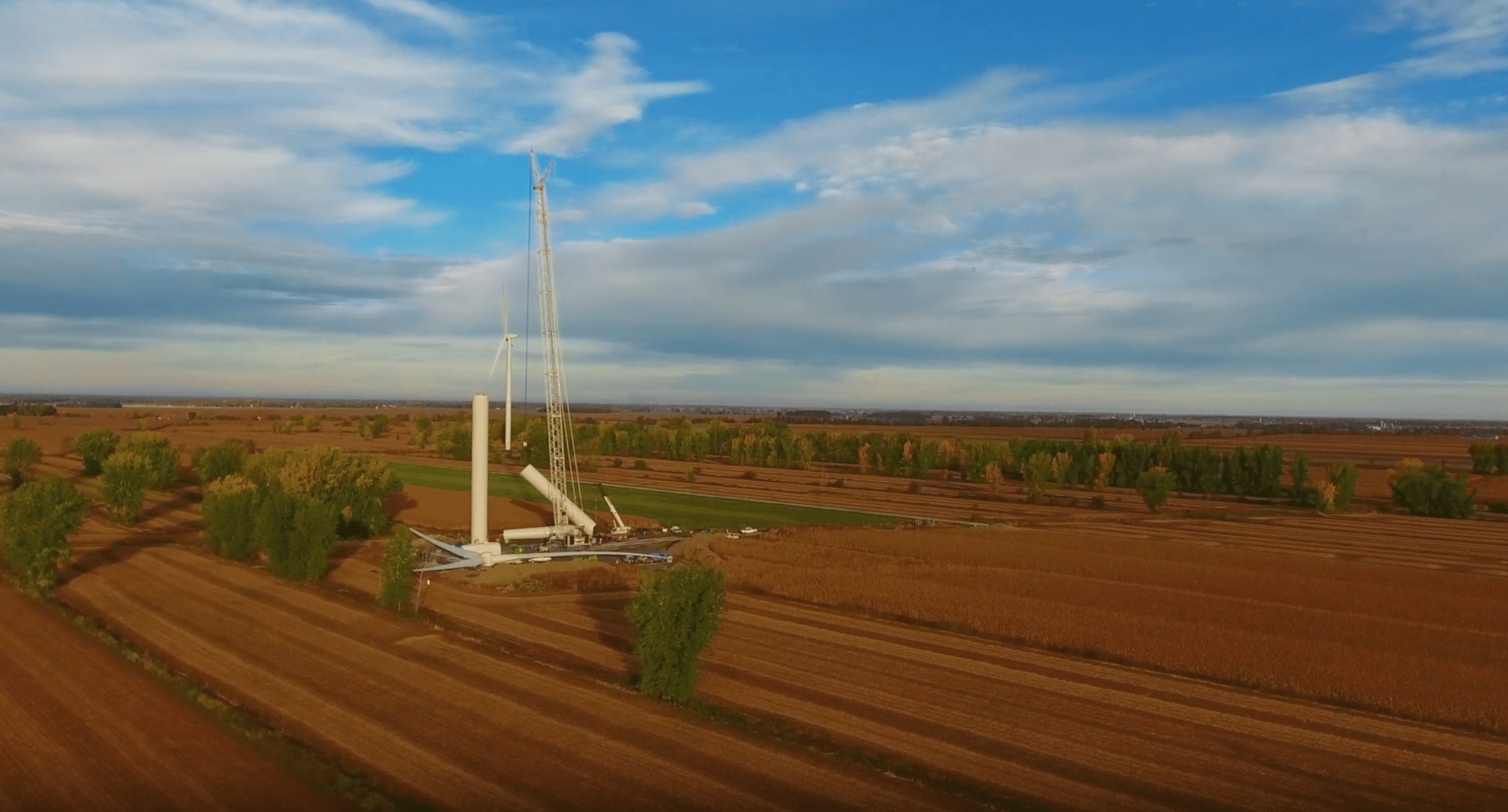 Vue aérienne d’un parc éolien en construction, montrant l’implantation des éoliennes dans un paysage agricole de la région.